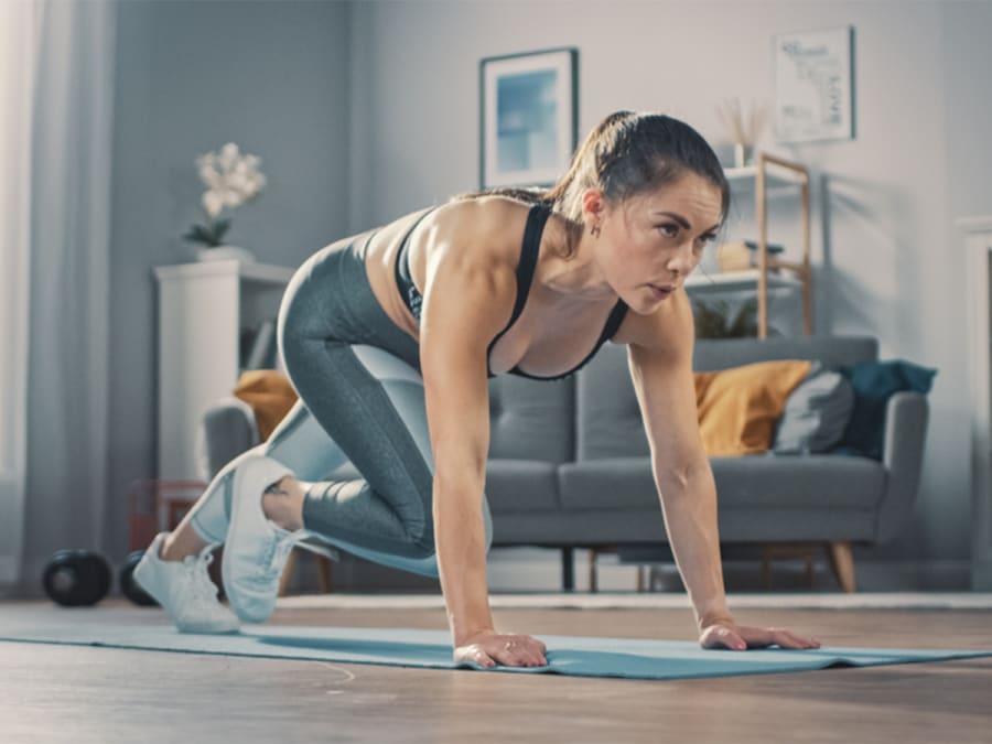 Person doing mountain climbers cardio exercise at home